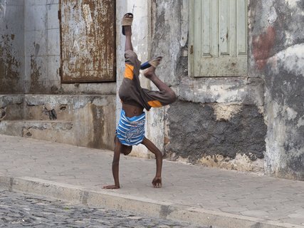 Ein Junge macht einen Handstand auf der Straße 