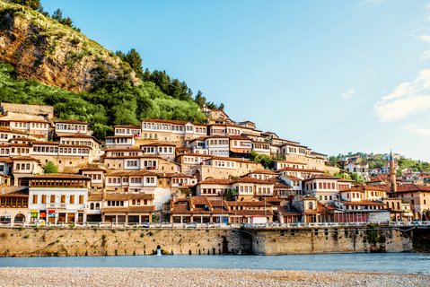 Blick auf ein albanisches Städtchen, dass sich an den Fuß eines Berges schmiegt