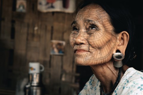 Portrait einer Frau mit einem dunklen Linienmuster auf dem Gesicht