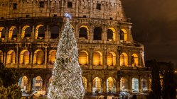 Ein beleuchteter Tannenbaum steht vorm Kolosseum in Rom