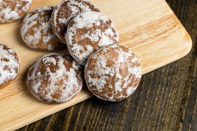 Ein paar Stücke Lebkuchen liegen auf einem Holzbrett