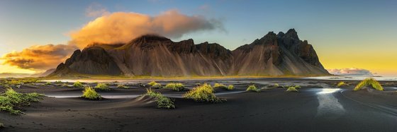 Eine Landschaft mit einem Gebirge und einem Gewässer im Vordergrund