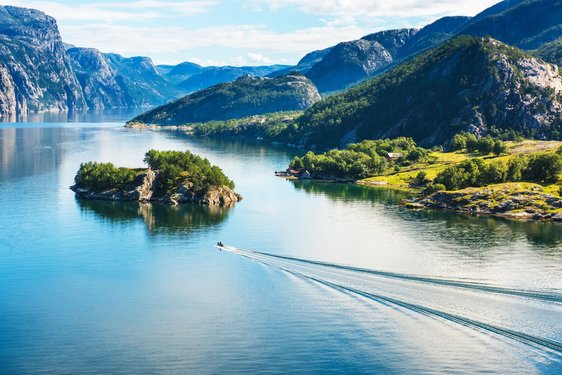 breites Gewässer mit kleiner Insel, zu dem ein Boot fährt