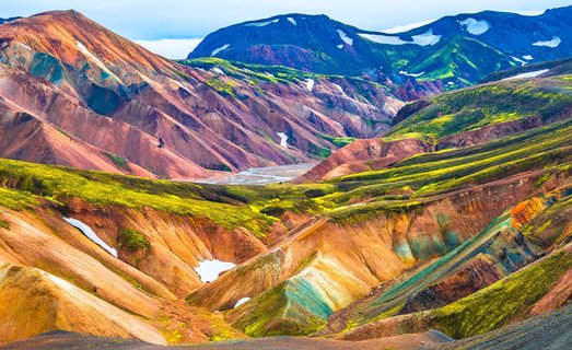 Eine farbenfrohe Berglandschaft, durch die ein Fluss fließt