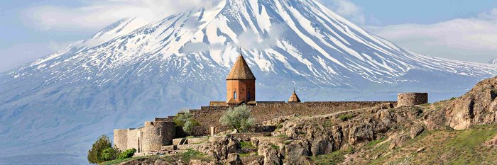 Eine erhöhte Klosteranlage mit Panoramablick auf den schneebedeckten Ararat