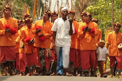 Indonesien Festparade auf Bali Männer in festlicher Kleidung laufen eine Straße entlang