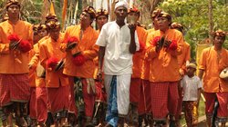 Männer in festlicher Kleidung laufen eine Straße entlang