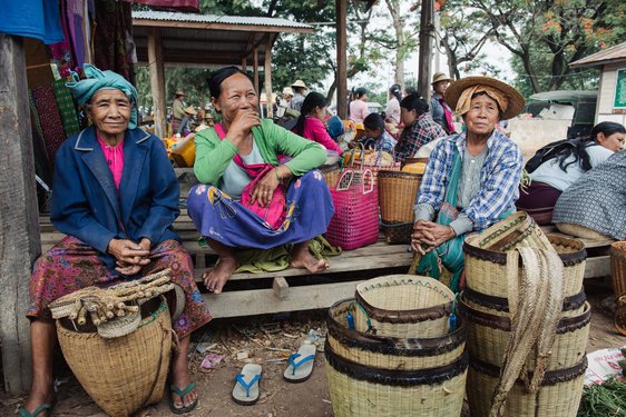 Frauen mit traditionellen Körben ruhen sich vom Einkaufen auf dem Markt aus