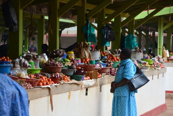 Afrikas Märkte bersten von Gemüse Auf einem mit einem weißen Tuch abgedeckten Marktstand liegt eine Vielzahl unterschiedlicher Gemüsesorten.