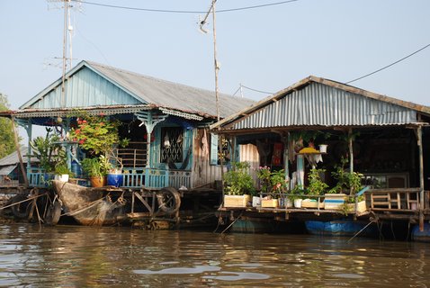 Zwei Hausboote mit dekorierten Verandas auf den Gewässern des Mekongdeltas.