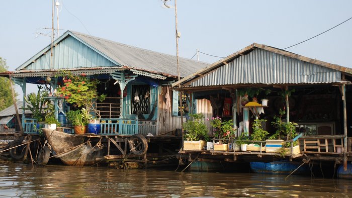Zwei Hausboote mit dekorierten Verandas auf den Gewässern des Mekongdeltas.