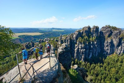 Wanderer blicken auf die Schrammsteine im Elbsandsteingebirge