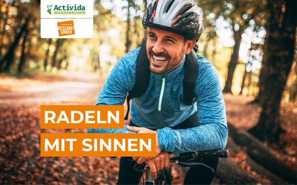Radeln mit Sinnen Ein Radfahrer steht im Wald und lächelt in die Kamera
