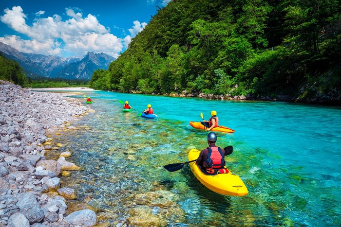 Eine Reisegruppe von Kajakfahrern entlang des Fluss Soca 