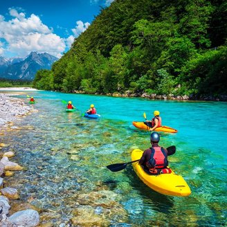 Eine Reisegruppe von Kajakfahrern entlang des Fluss Soca 