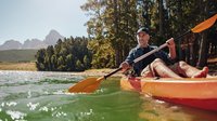 Kanufahrt auf einem Fluss Ein Mann sitzt in einem Kanu und fährt über den Fluss