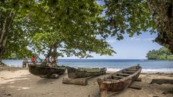 Holzboote am Strand Praia da Colónia Açoriana von São Tomé und Príncipe Holzboote unter Bäumen am Strand