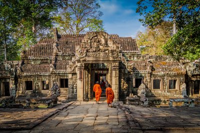 Zwei Mönche laufen auf einem Weg auf einen alten Tempel zu
