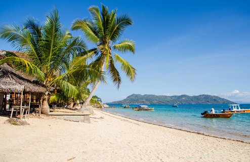 Palmen und Boote am Strand von Madagaskar