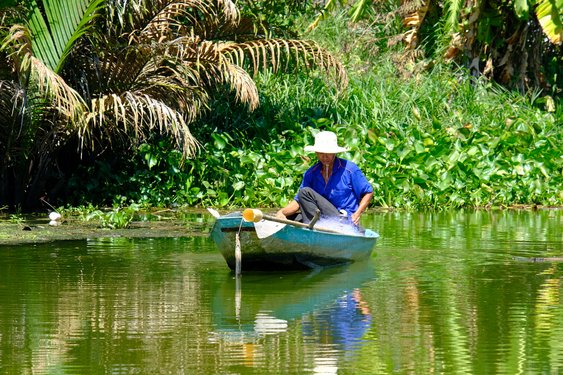 Ein Fischer im Boot auf dem Mekongdelta