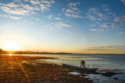 Fischerboot am Ufer eines Sees bei Sonnenuntergang 
