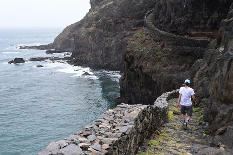 Eine Wanderin wandert entlang der Küste auf Santo Antão