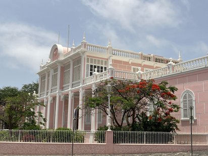 Koloniale Architektur in Mindelo Man sieht einen rosa gestrichenen Prachtbau im Kolonialstil.