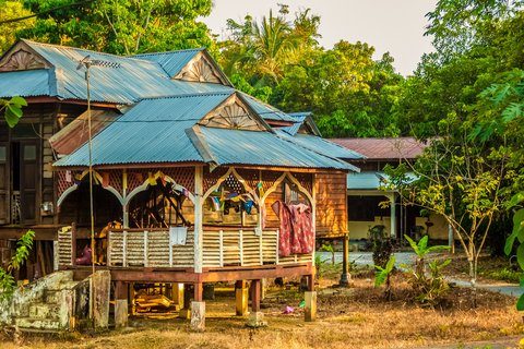 Ein im Dschungel eingebettets Stelzenhaus in einem Dorf in Malaysia.