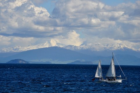 Zwei Segelboote auf einem See und Bergkette im Hintergrund