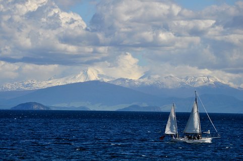 Zwei Segelboote auf einem See und Bergkette im Hintergrund