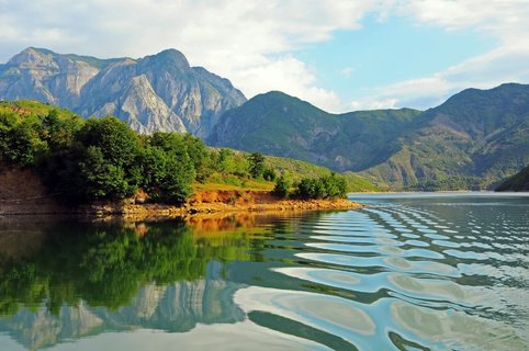 Blick vom See aus über das Ufer auf ein schönes Bergpanorama