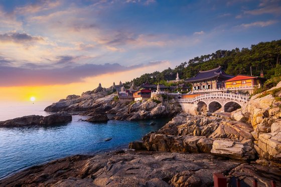 Das Bild zeigt den Yonggungsa Tempel in Busan, welcher direkt am meer liegt und von der untergehenden Sonne angestrahlt wird.