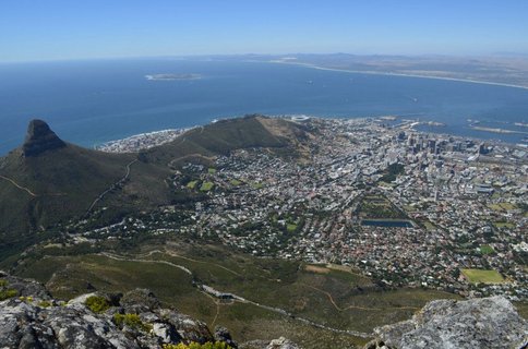 Blick vom Berg hinab auf Kapstadt und das Meer im Hintergrund
