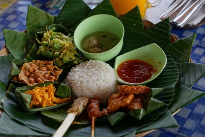 Traditionelles Speisen auf Bali in Indonesien kleine angerichtete Portionen auf einem Bananenblatt
