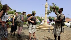 Reisegruppe mit Guide vor ehemaligem Sklavenpranger auf Santiago.