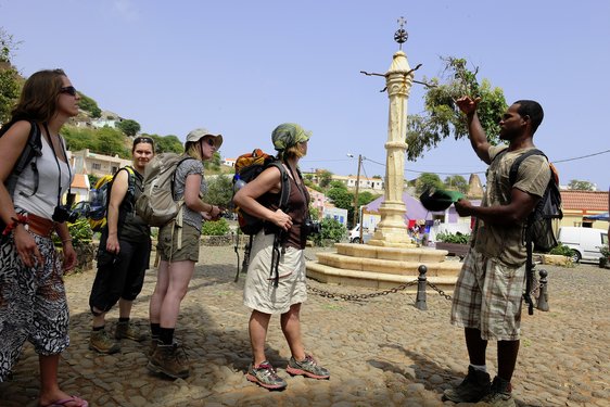 Reisegruppe mit Guide vor ehemaligem Sklavenpranger auf Santiago.