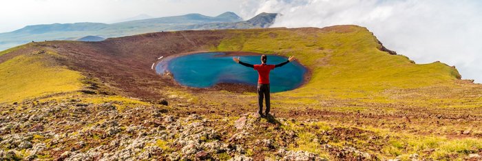 Eine Wanderin vor einem Vulkansee im Geghamgebirge in Armenien
