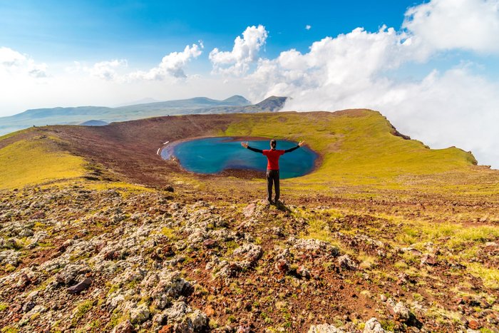Eine Wanderin vor einem Vulkansee im Geghamgebirge in Armenien