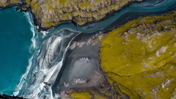 Ein Fluss fließt auf den Färöer-Inseln ins Meer
