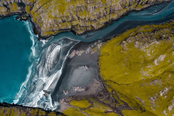 Raue Natur zwischen Meer, Seen, Flüssen und kargem Land Ein Fluss fließt auf den Färöer-Inseln ins Meer