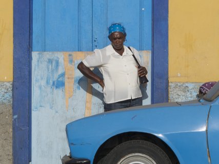 Eine einheimische Frau schaut sich ein blaues Auto an