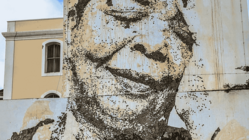 An einer Häuserwand prangt groß über zwei Stockwerke ein Schwarz-Weiß-Bildnis Cesaria Evoras.