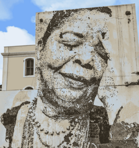 An einer Häuserwand prangt groß über zwei Stockwerke ein Schwarz-Weiß-Bildnis Cesaria Evoras.