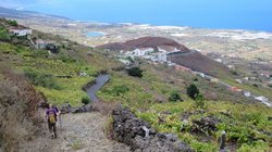 Eine Wanderin beschreitet einen Weg abwärts in das Gulfo-Tal auf El Hierro.