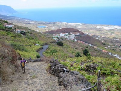 Eine Wanderin beschreitet einen Weg abwärts in das Gulfo-Tal auf El Hierro.