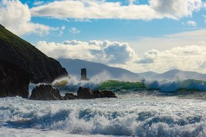 Hohe Wellen an einem Strand in Kinard mit Klippen im Hintergrund