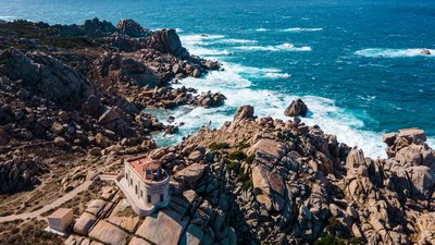Schroffe Küste am Capo Testa auf Sardinien Eine schroffe Klippe ragt aus blauem Meer heraus