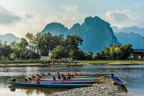 bunte, lange, schmale Boote liegen am Ufer