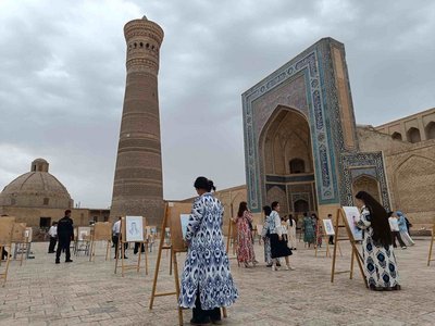 Auf einem von orientalischen Prachtbauten umstellten Platz stehen Maler vor ihren Paletten.