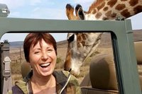 Eine EcoVolunteer-Teilnehmerin wird von einer Giraffe begutachtet.